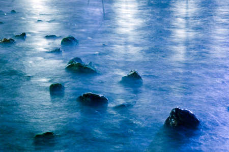 Reflections of cold light on water in the night. Long Shutter, artistic blurの写真素材
