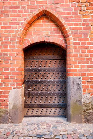 Old wooden door with brick arch facadeの写真素材