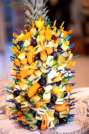 Many canapes of exotic fruits - kiwi, grape, mandarin, pineapple. The original filing of fruit snacks at celebration. Catering outdoors, summerの写真素材