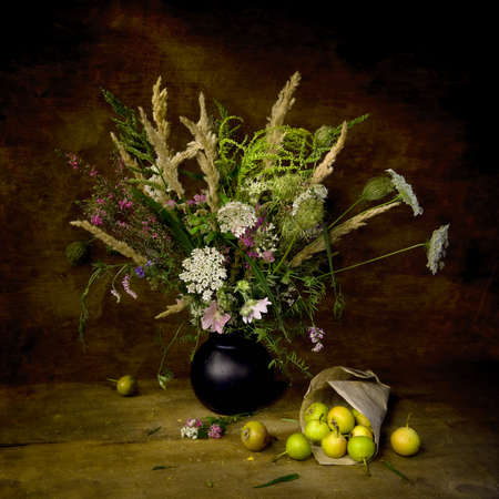 Summer bouquet  with wild flowers and pears on the wooden table with natural light. Still life looking like a painting.の写真素材