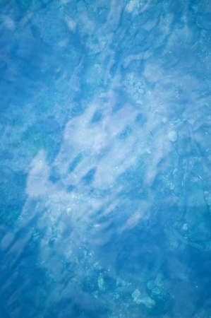 Blue water of sea ocean and pebbles on the bottom. Sea water backgroundの写真素材
