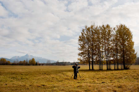 Ruzomberok, Slovakia - October 29, 2011:  Photographer using a professional digital camera on a tripod, natural landscape on background.  Popular photography seminar in Ruzomberok was held at the Association of Slovak Photographers.のeditorial素材