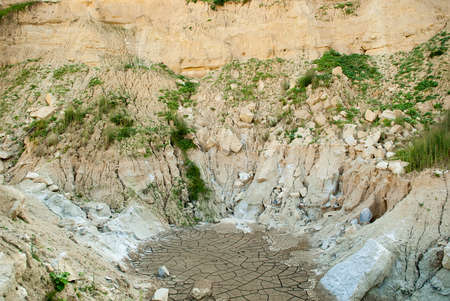 Cracked clay ground into the dry season at a forsaken quarryの写真素材