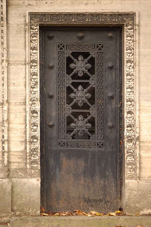Old ornate iron door. Entrance to an old tomb, crypt at a cemetery.の写真素材