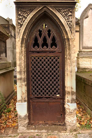 Old ornate iron door. Entrance to an old tomb, crypt at a cemetery.の写真素材