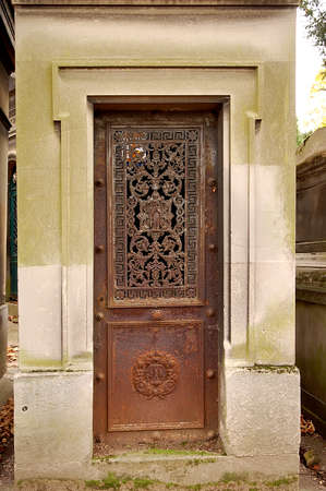 Old ornate iron door. Entrance to an old tomb, crypt at a cemetery.の写真素材
