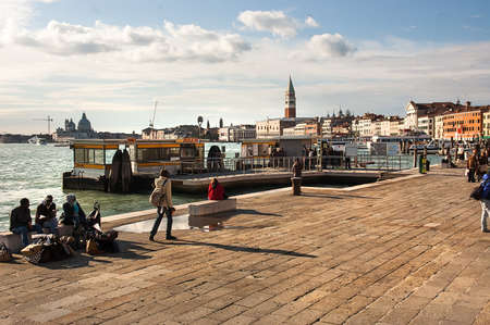 Venice, Italy - October 29, 2009: Tourists on Riva Ca di Dio against view on Grand Channel and Santa Maria della Salute. The city has attracted a lot of tourists in this month of the year.のeditorial素材
