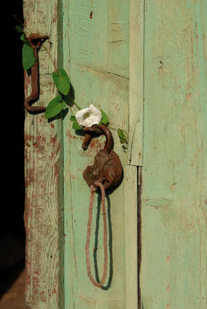 Old rusty metal iron padlock with key on a wood doorの写真素材