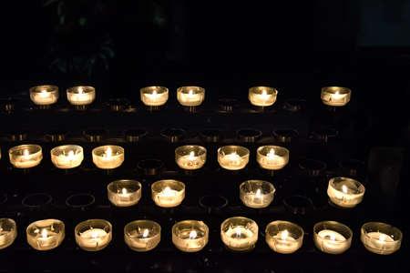 Abstract candles background with a golden light of candle flameの写真素材