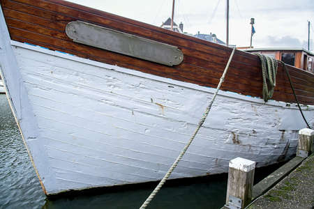 Old yacht fixed with ropes in the harborの写真素材