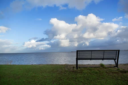 Wooden bench on open space overlooking a beautiful sea viewの写真素材