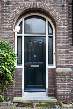 Beautiful black arch entrance door with brick wallの写真素材