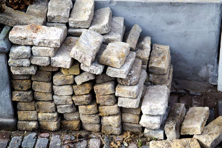 Pile of bricks on one of the city streets (taken by an old pavement)の写真素材