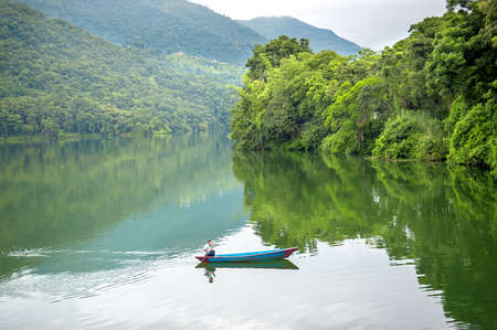 Small wooden boat on the Phewa Lake in Pokhara, Nepalの写真素材