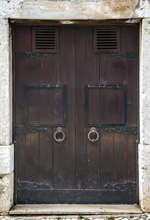 Old wooden door with forged hinges.の写真素材