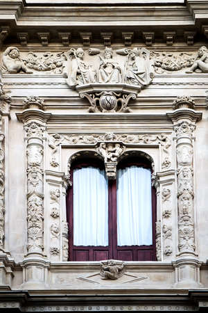 Window decorated with carving and sculptures in neo-baroque styleの写真素材