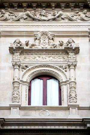 Window decorated with carving and sculptures in neo-baroque styleの写真素材