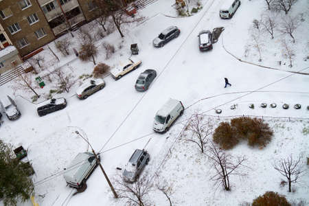 View from above to the yard of residential building after snowfall with snow covered cars. Selective focusの写真素材