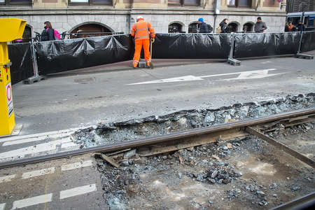 Amsterdam, Netherlands - February 9, 2018: Street scene with worker installing fence, repairing tram lines. Selective focusのeditorial素材