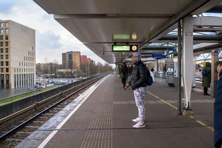 Amsterdam, Netherlands - February129, 2018: Commuters and tourists waiting on a platform of tram station. Selective focusのeditorial素材