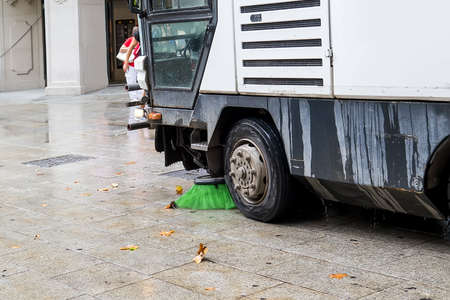 Barcelona, Spain - Aug 9, 2018: Machine sweeper - cleaner cleans the roadway. Machin brushes sweeping the street. The car vacuumed on the street. Municipal equipmentのeditorial素材