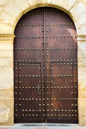 Nice old dark medieval wooden brown door with round bronze nails. Selective focusの写真素材