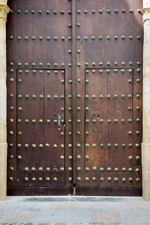 Nice old dark medieval wooden brown door with round bronze nails. Selective focusの写真素材