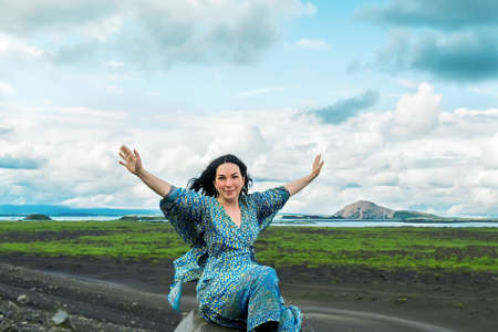 Happy woman in blue dress an amazing coast of west Icelandの写真素材