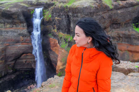 Woman traveler at beautiful scenery of the majestic Haifoss Waterfall in countryside of Iceland in summer. Selective focusの写真素材