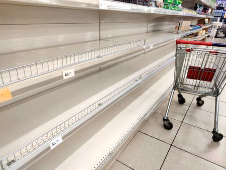 Empty shelves in a supermarket. Many shops are low on goods due to floods preventing deliveries and panic buyingの写真素材