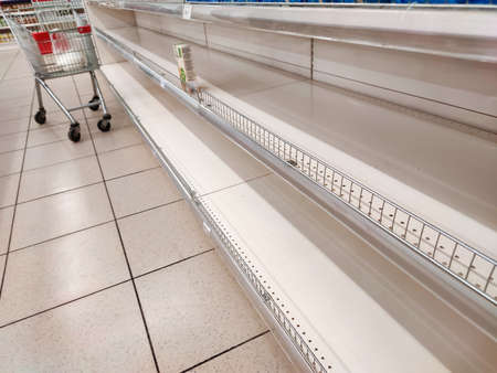 Empty shelves in a supermarket. Many shops are low on goods due to floods preventing deliveries and panic buyingの写真素材