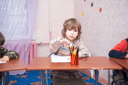 Boy sitting at the table, writing homework or preparing for the exam, home education. Selective focusの写真素材