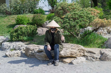 Teenager in traditional Japanese garden in Kyoto Park. Kyiv(Kiev). Ukraine. Selective focusの写真素材