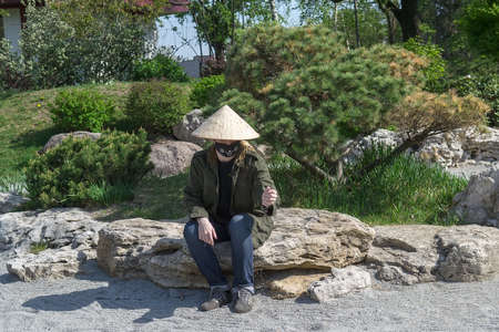 Teenager in traditional Japanese garden in Kyoto Park. Kyiv(Kiev). Ukraine. Selective focusの写真素材