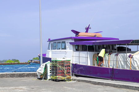 Maldives, Dhigurah - 15 Feb 2022: Blue vessel moored at pier with tarpaulin-covered area, blue gas...