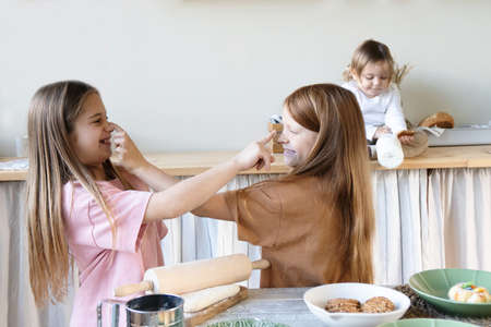 Beautiful children cooking baking and playing together.The concept of joint pastime and relationships. Front view.Three children.の写真素材