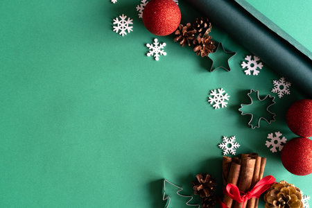 Christmas wooden natural decorations, red balls, gift box and notepad on green background. Christmas...