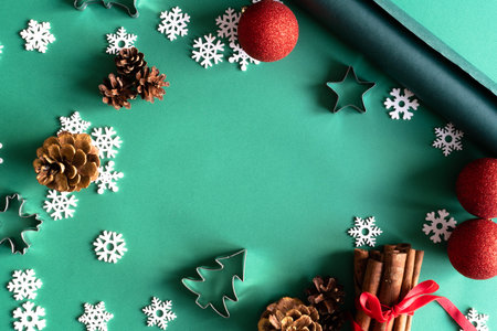 Christmas wooden natural decorations, red balls, gift box and notepad on green background. Christmas...