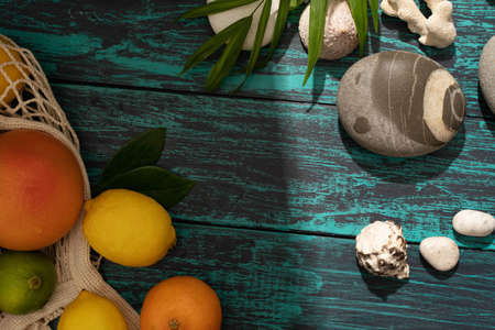 Beautiful summer holiday, fruits , orange, palm leaves on a shabby blue wooden background. The concept of summer and relaxation at sea, eco products ,holidays with family in a pleasant seaside resort.の写真素材