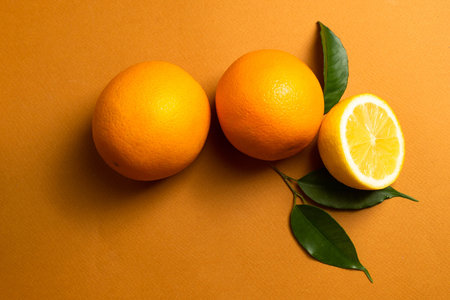 Juicy orange fruits with green leaves on an orange banner for your design. Copy space. The concept...