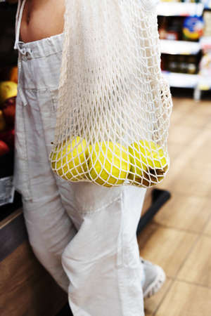 Woman shopping at market. A hand with an ecological fruit bag.の写真素材