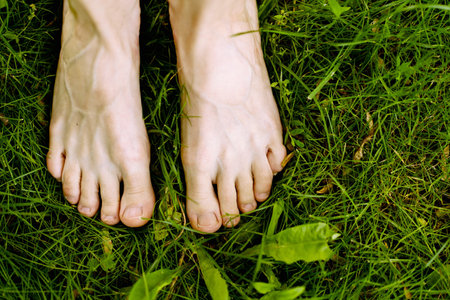 Bare womans feet on the green grass. The concept of health and naturalness.の写真素材