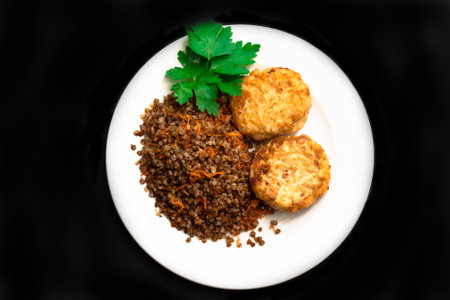 Healthy dinner. Top view, flat lay. Lunch bowl with buckwheat porridge, fried chicken cutlets . Black isolated background.の写真素材