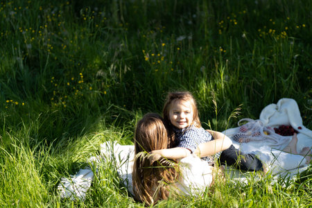 Brother and sister happily hug and laugh, lying on the green grass. The sun is shining, the children are happy carefree. The concept of a happy family life and bonding. Copy space.の写真素材
