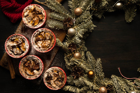 Christmas composition. Christmas cupcakes in red plates. Traditional holiday dessert. Copy space. Dark background. Flat lay.の写真素材
