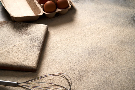Baking background with flour,cutting board, eggs on a table, high angle photo view.
