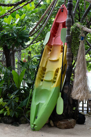 Colorful colorful canoe leaning against a tree on a tropical beach. Koh Phangan, Thailand , Asia.の写真素材