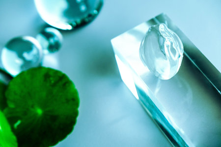 Aloe serum and centella drops rest on a clear surface.の写真素材