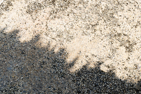 Shadow cast on textured pavement creates a unique pattern.の写真素材