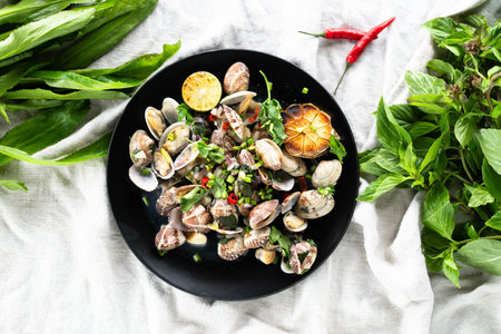 Garlic clams are beautifully arranged on a plate with fresh herbs and sliced lime.の写真素材